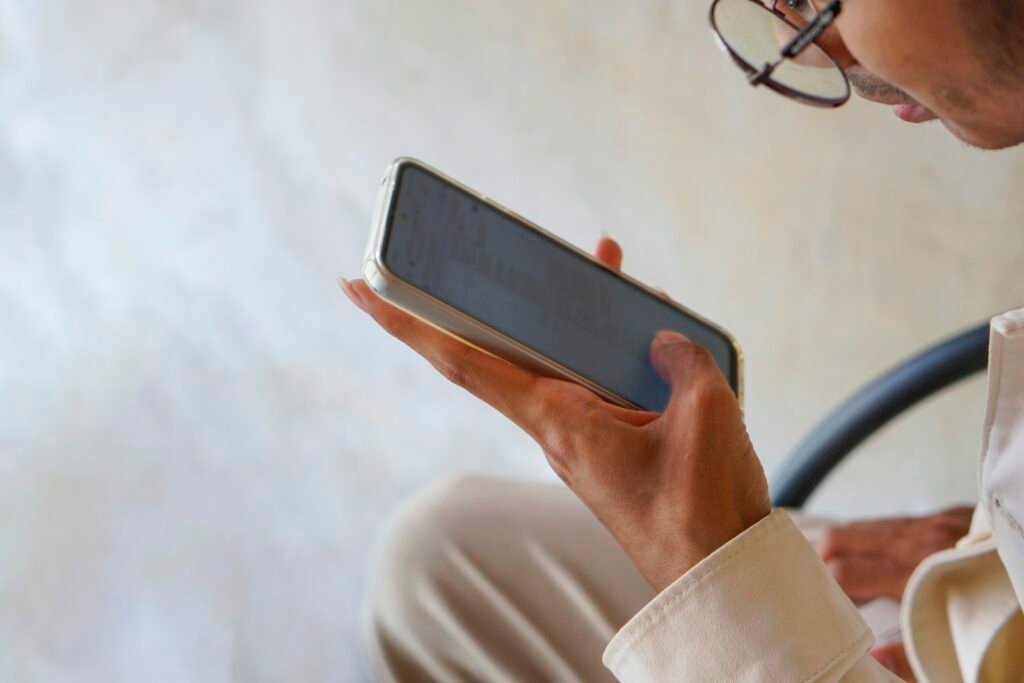 Person holding a smartphone, representing an AI voice cloning scam phone call