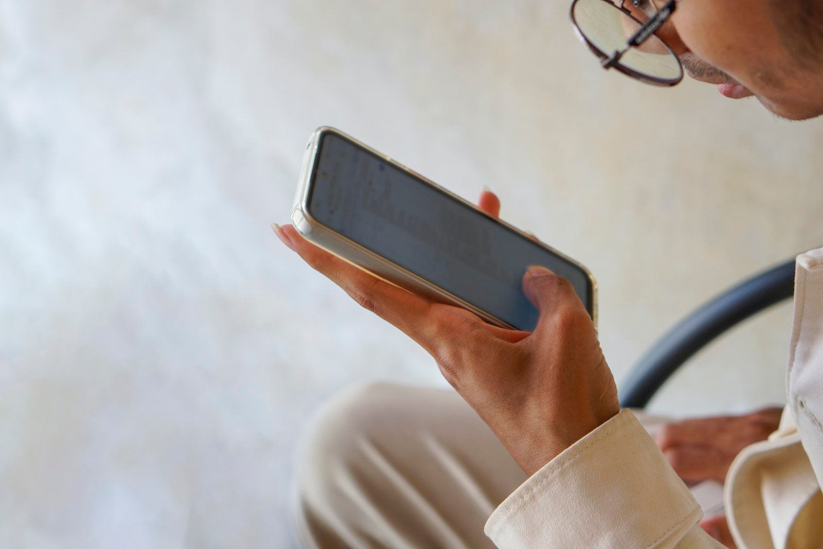 Person holding a smartphone, representing an AI voice cloning scam phone call