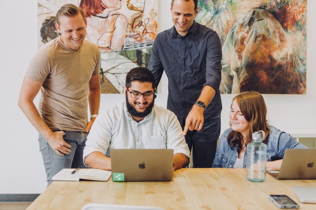 Tiny AI teams collaborating around a laptop