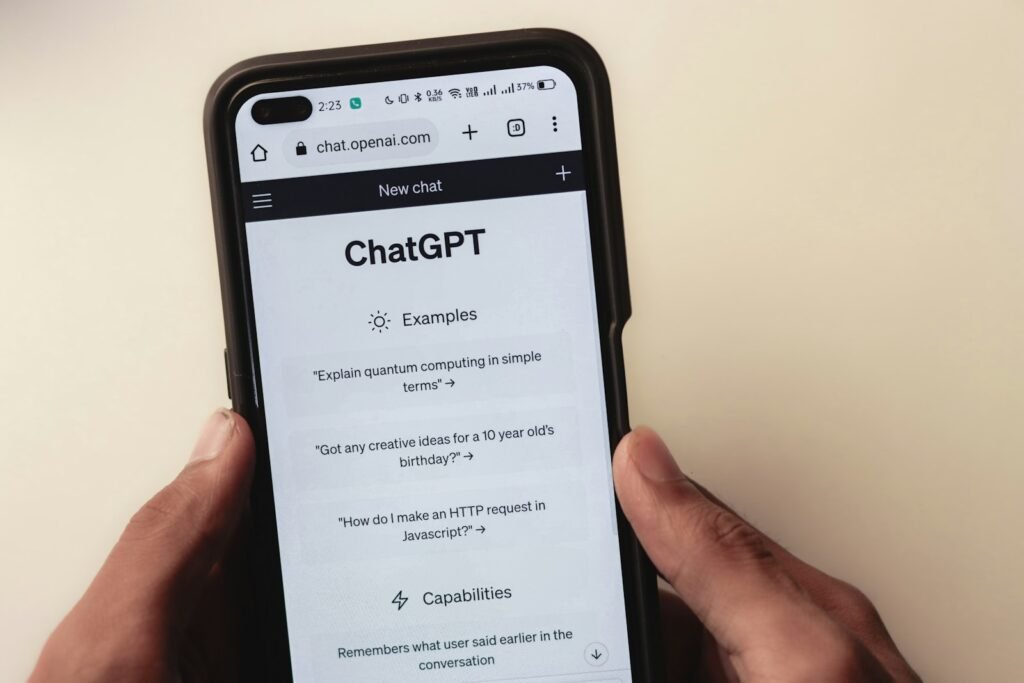 Person holding a phone showing the ChatGPT app, representing advertising on ChatGPT