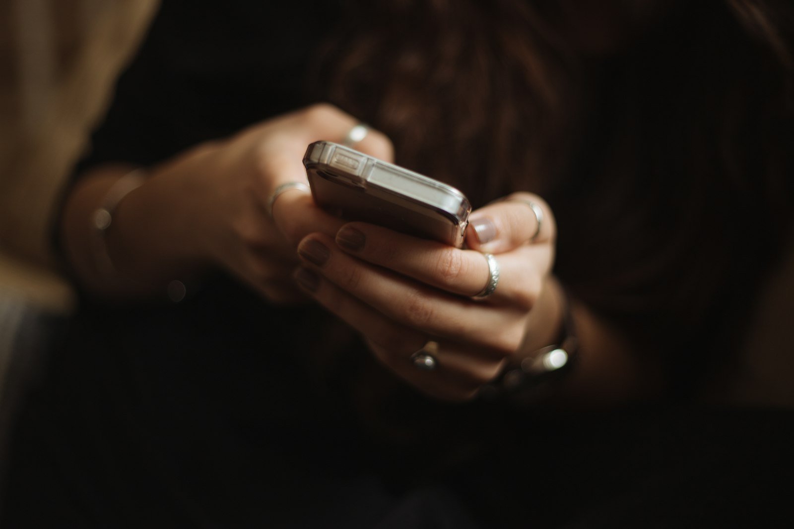 Person holding a phone, representing an AI voice cloning scams call from a supposed family member