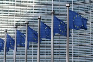 Row of European Union flags at the European Commission building, representing the Google Search Europe dispute